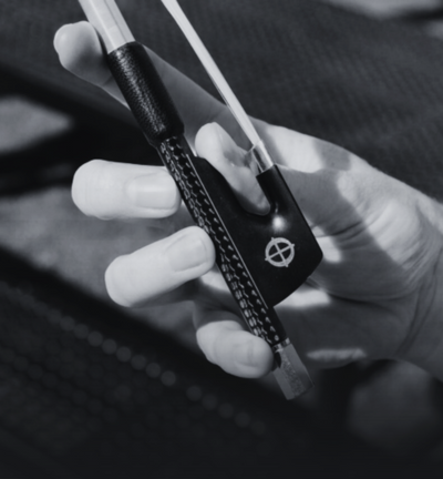 Hand holding a black and silver lock with a brand logo, blurred background