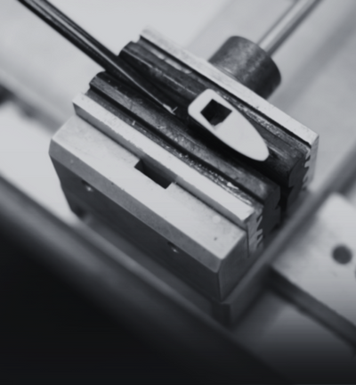 a bow tip in a clamp in a workshop