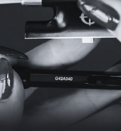 Close-up of a CodaBow with 'G42A040' marking on a dark background