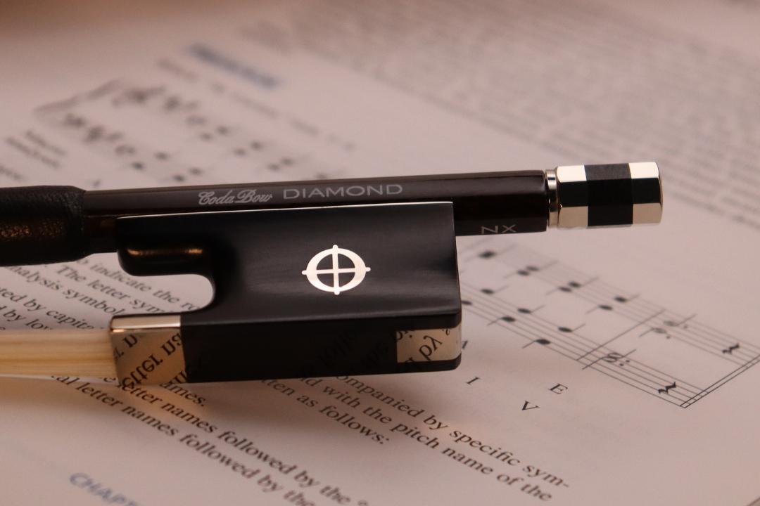 Violin bow on sheet music with 'Diamond' branding