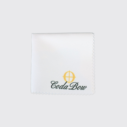 A small, white cleaning cloth with a scalloped edge rests on a plain gray background.  It displays an embroidered logo: a stylized target symbol above the words "Coda Bow" in black script.