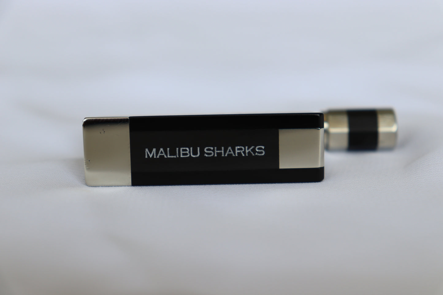 A black and silver colored slide with the text 'MALIBU SHARKS' engraved on it.